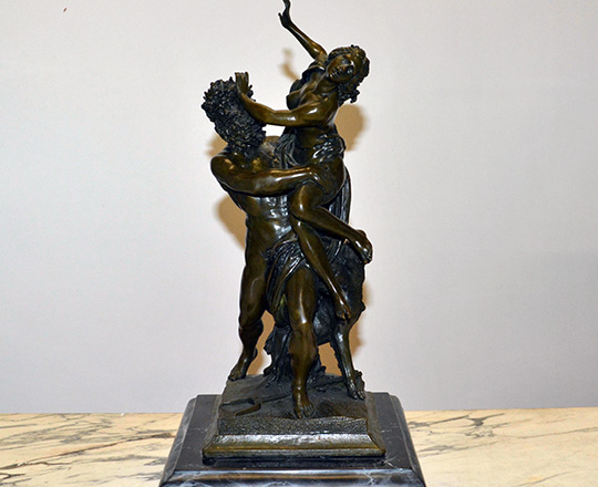 Lot 386: Dark medal color bronze statue of woman captured by faun. H 38 cm.